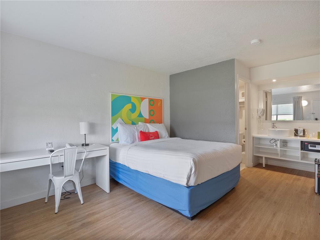 A bedroom features a bed, a desk with a chair, and an open vanity area — 5367 W IRLO BRONSON MEMORIAL HIGHWAY UNIT 1-120, KISSIMMEE, FL