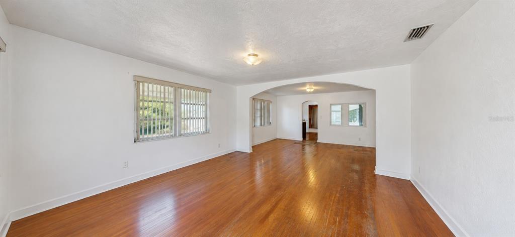 A kitchen features light-colored cabinets, a black refrigerator, a black stove, and wood flooring — 415 MODEL STREET, DAYTONA BEACH, FL