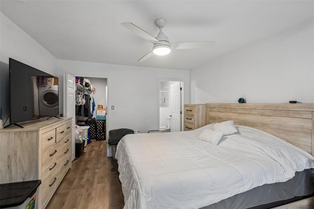A bedroom with a bed, dresser, ceiling fan, closet, and an attached bathroom — 526 E JESSUP AVENUE, LONGWOOD, FL