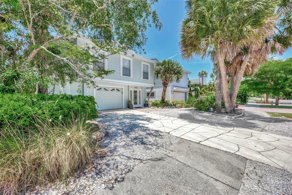 A two-story light blue house with a gravel driveway and palm trees in the front — 5516 AVENIDA DEL MARE, SARASOTA, FL