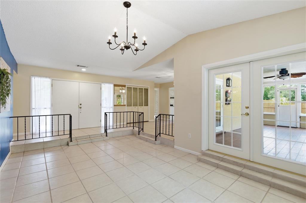 A tiled living area features a sunken floor, black railings, and a chandelier — 6538 NIGHTWIND CIRCLE, ORLANDO, FL