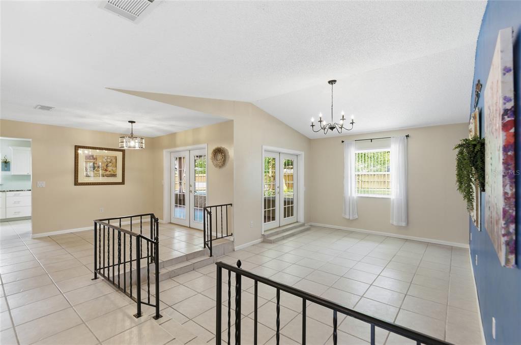A split-level living area with tiled floors, white walls, and two sets of glass doors — 6538 NIGHTWIND CIRCLE, ORLANDO, FL