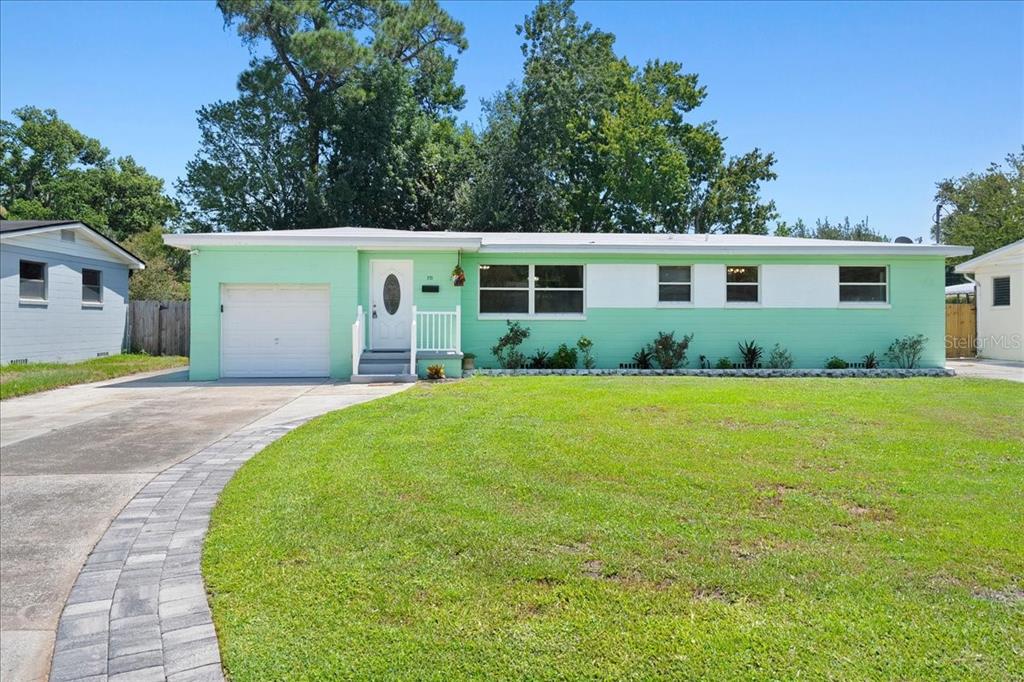 A single-story house with mint green and white exterior paint, a garage, and a lawn — 2125 W LOU DRIVE, JACKSONVILLE, FL