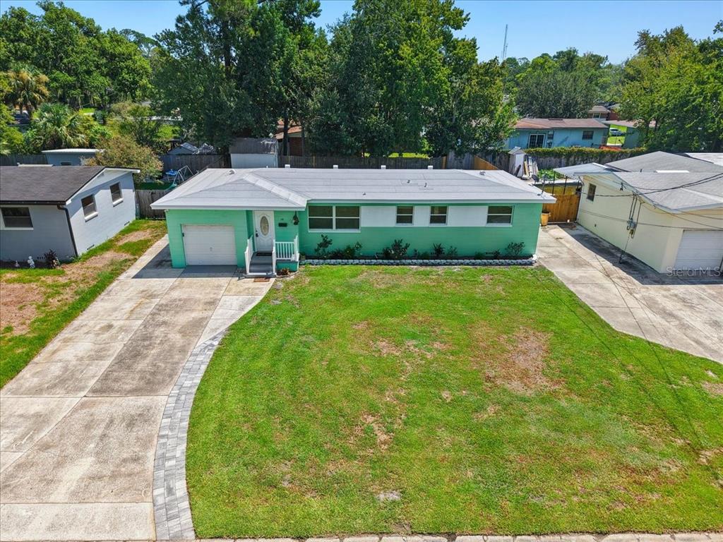 An exterior view of a single-story green house with a front garage and driveway — 2125 W LOU DRIVE, JACKSONVILLE, FL