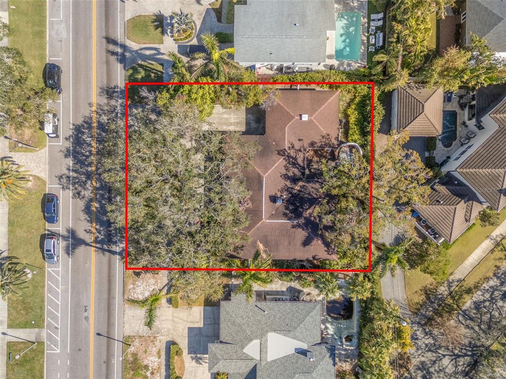 A single-story house with a concrete driveway and large oak trees in the front yard — 215 SNELL ISLE BOULEVARD NE, ST PETERSBURG, FL