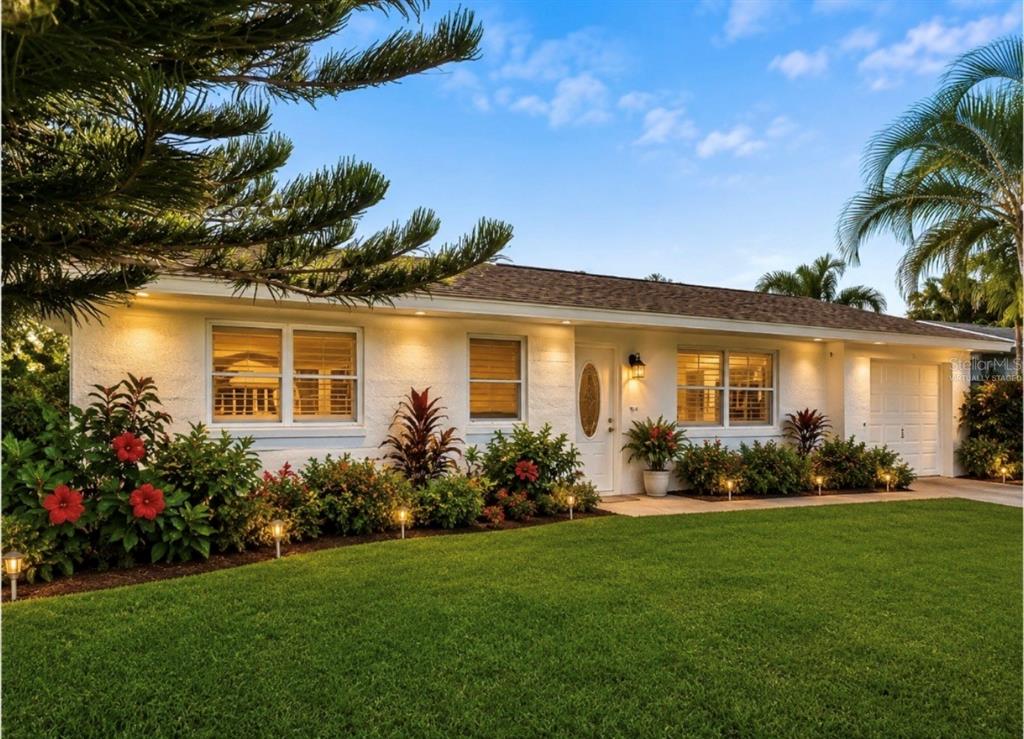 A single-story white house with a lawn, landscaping, and a garage under a blue sky — 192 PONCE DE LEON DRIVE, ORMOND BEACH, FL