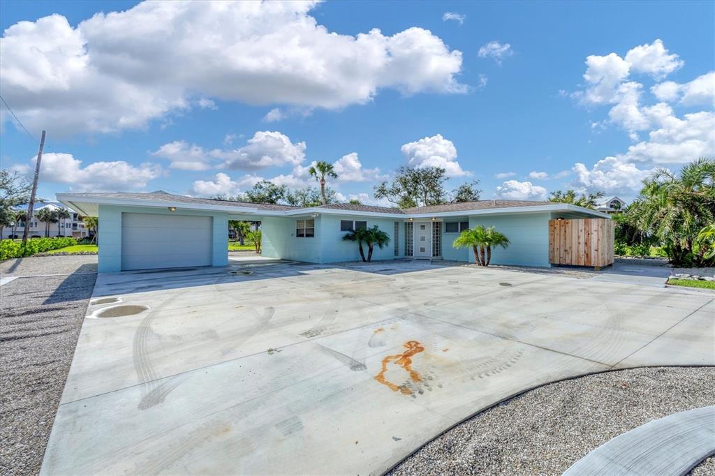 A light blue, single-story house with a garage and a large concrete driveway — 550 GASPAR DRIVE, PLACIDA, FL