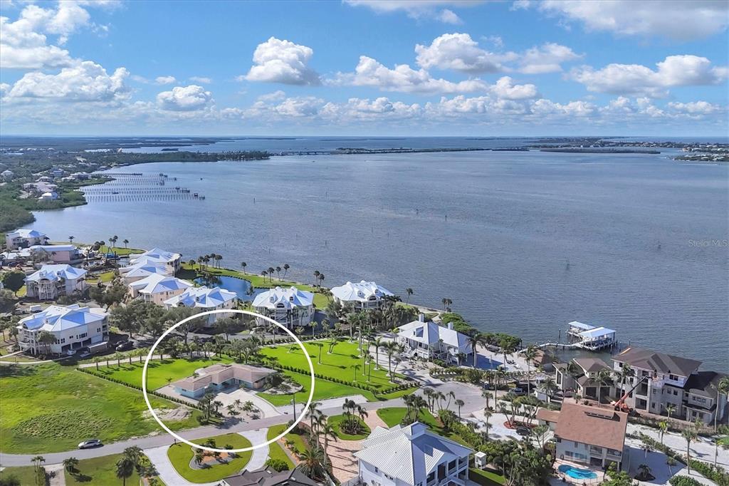 An aerial view shows a single-story house with a light blue exterior and a large lawn — 550 GASPAR DRIVE, PLACIDA, FL