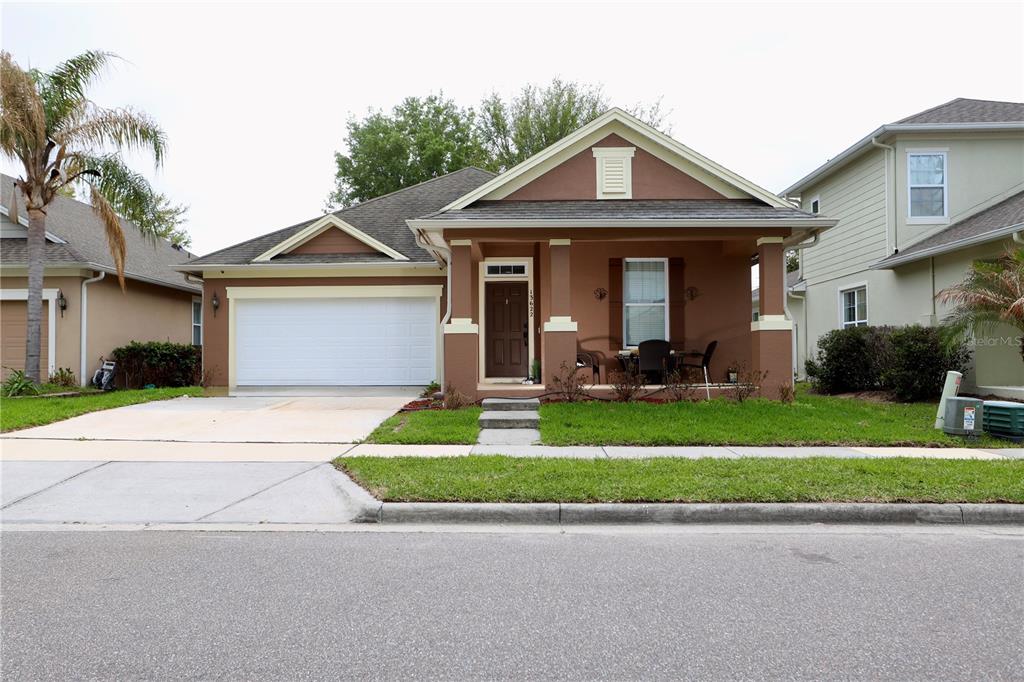 A single-story house with a brown exterior, a two-car garage, and a covered front porch — 13622 DARCHANCE ROAD, WINDERMERE, FL
