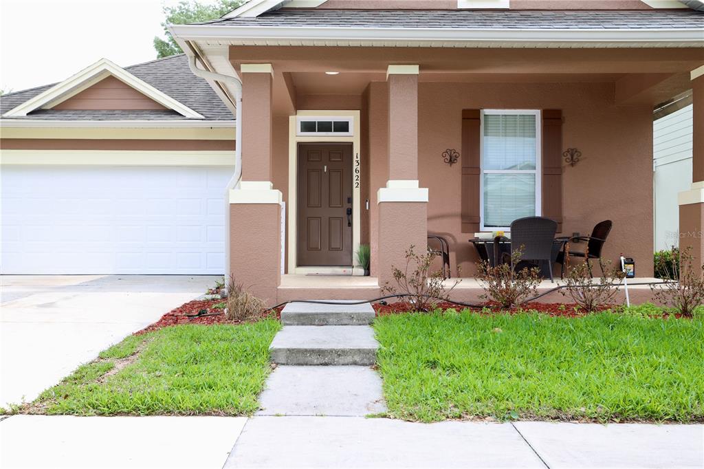 The exterior of a brown house features a front porch, a garage, and a walkway — 13622 DARCHANCE ROAD, WINDERMERE, FL