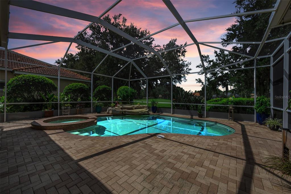 A screened-in patio features a swimming pool, a raised hot tub, and brick pavers — 1453 EL PARDO DRIVE, TRINITY, FL