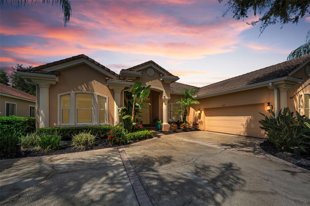A single-story house with a beige stucco exterior, a tile roof, and a concrete driveway — 1453 EL PARDO DRIVE, TRINITY, FL