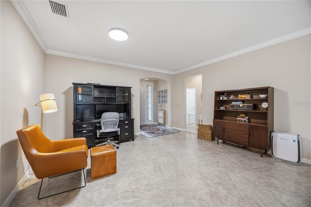 A home office with tile flooring, a desk, a leather armchair, and a wooden hutch — 5516 CARTAGENA DRIVE, SARASOTA, FL