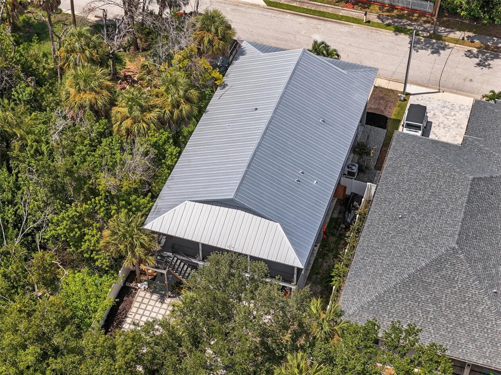 An aerial view shows a house with a metal roof and a rear covered porch — 170 E SPRUCE STREET, TARPON SPRINGS, FL