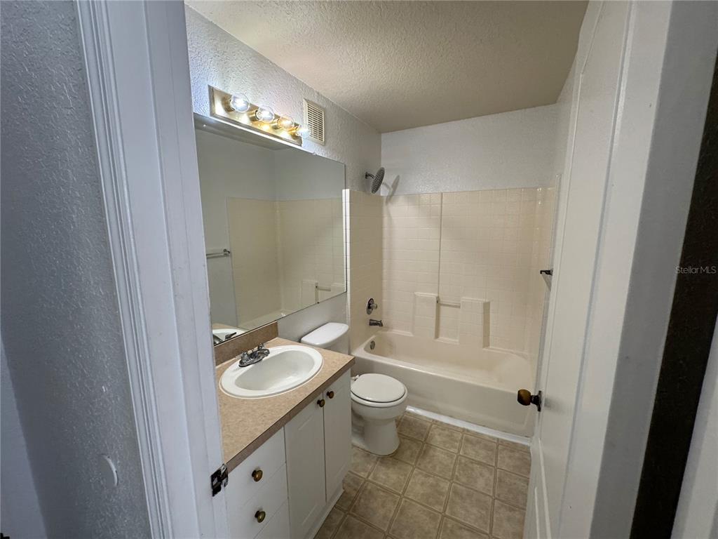 A bathroom features a vanity with a sink, a toilet, and a shower-tub combination — 3325 S KIRKMAN ROAD UNIT 438, ORLANDO, FL