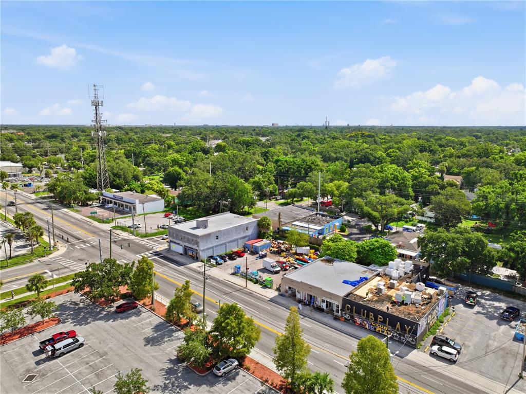 An aerial view shows a commercial street with a nightclub, parking lots, and surrounding trees — 8145 N NEBRASKA AVE, TAMPA, FL