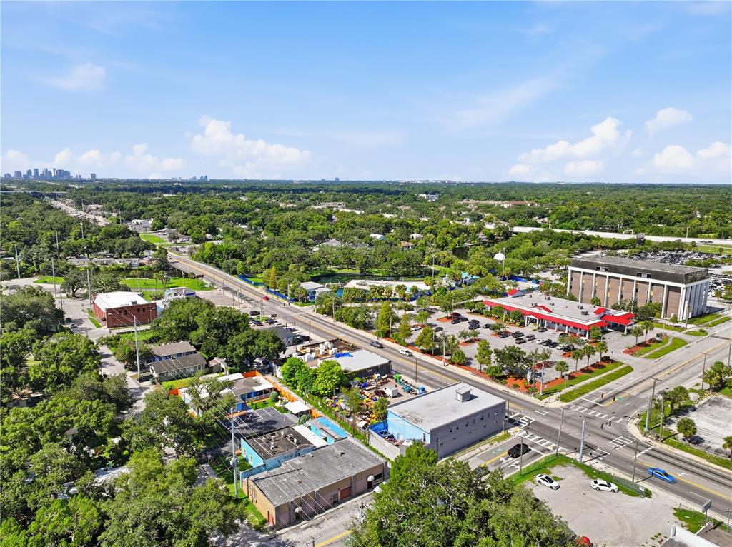 An aerial view shows a commercial area with buildings, parking lots, and surrounding trees — 8145 N NEBRASKA AVE, TAMPA, FL