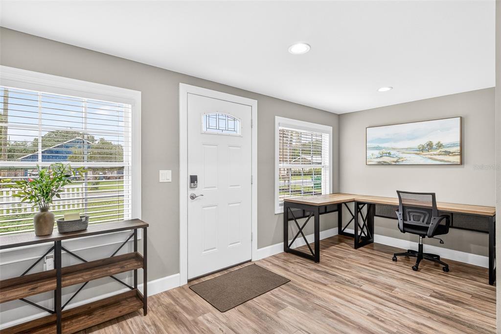 A home office with a desk, shelving unit, and front door on light wood floors — 420 E CYPRESS STREET, WINTER GARDEN, FL
