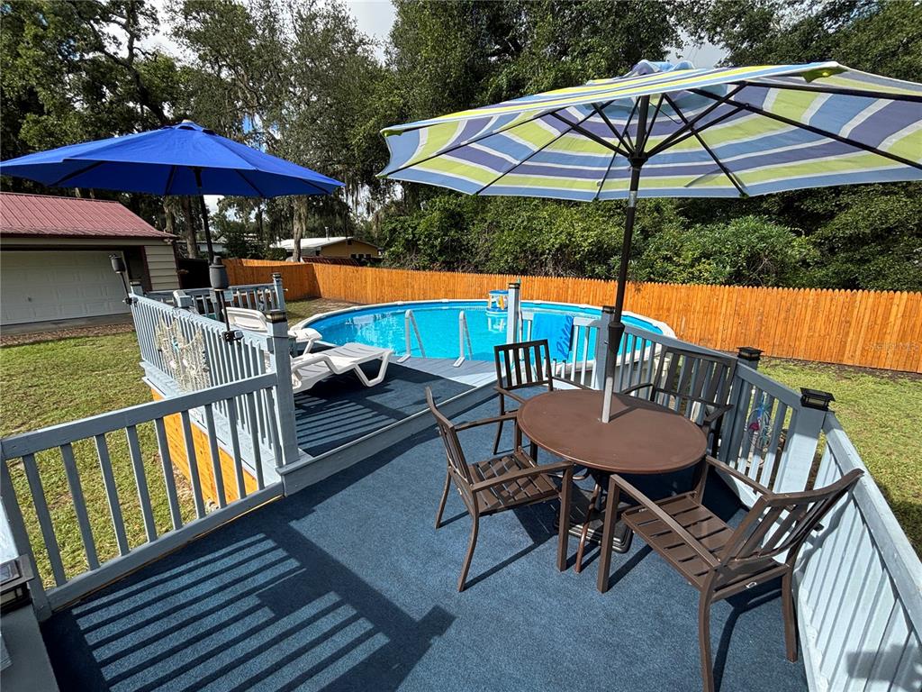 An elevated deck features a dining set, lounge chairs, and a swimming pool — 1762 SE 173RD AVENUE, SILVER SPRINGS, FL