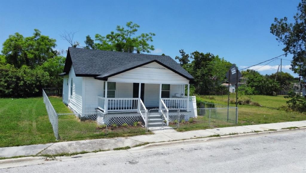A white, single-story house with a front porch and black roof sits on a grassy lot — 204 GARDEN AVENUE, ORLANDO, FL