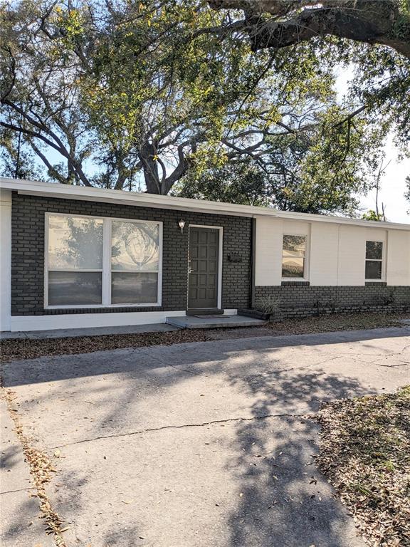A single-story house with a gray brick facade, white trim, and a concrete driveway — 3006 E ANDERSON STREET, ORLANDO, FL