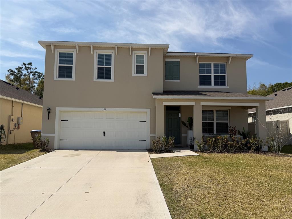 A two-story beige house with a two-car garage and a front porch — 328 CONWAY AVENUE, ST CLOUD, FL
