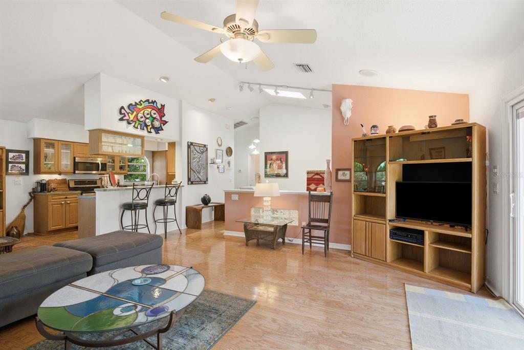 A bright art studio room features a patterned rug, glass doors, and various displayed artworks — 755 SAN CHRISTOPHER DRIVE, DUNEDIN, FL