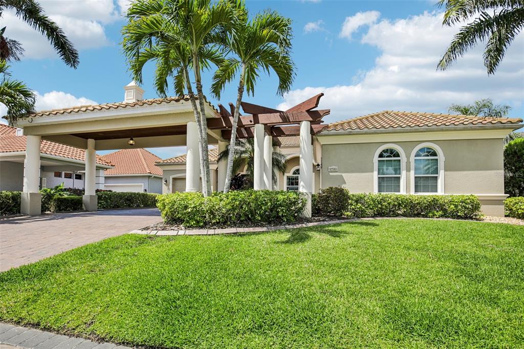 A single-story house with a large porte-cochère, a tiled roof, and a manicured front lawn — 4741 MAINSAIL DRIVE, BRADENTON, FL