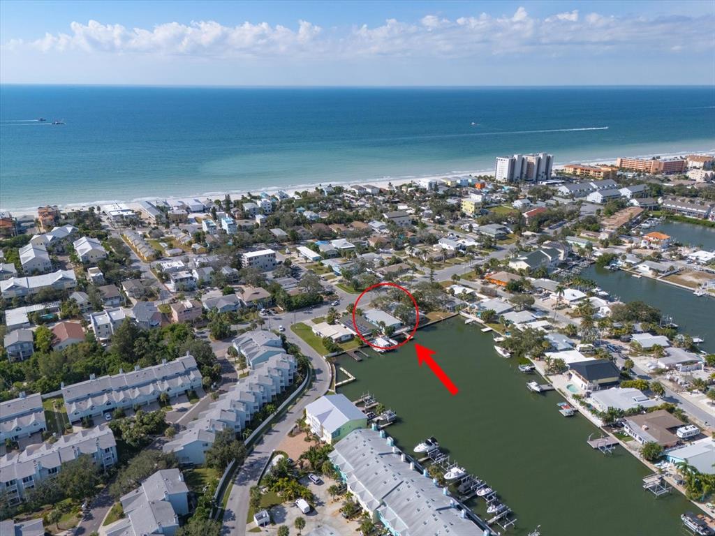 An aerial view shows a waterfront house with a boat dock on a canal — 711 E GULF BOULEVARD, INDIAN ROCKS BEACH, FL