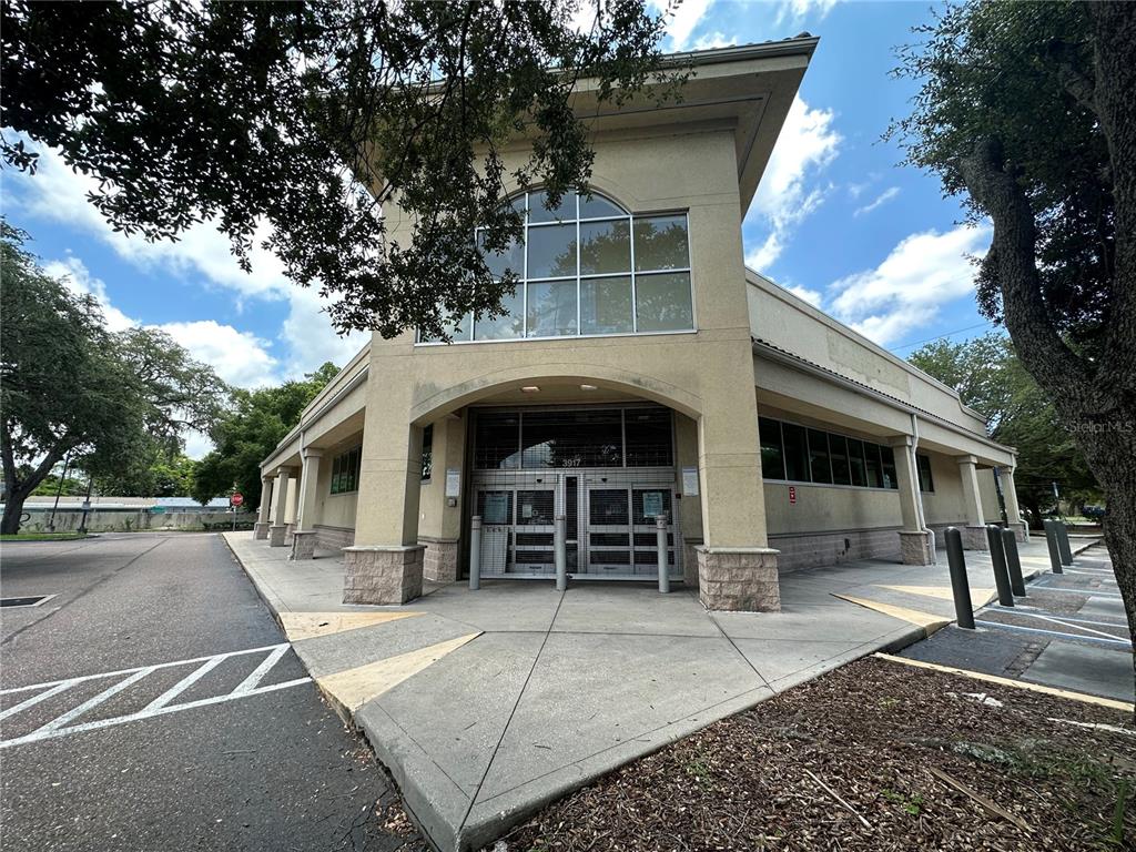 A beige commercial building with a glass entrance and large arched window under a roofline — 3917 N NEBRASKA AVENUE, TAMPA, FL