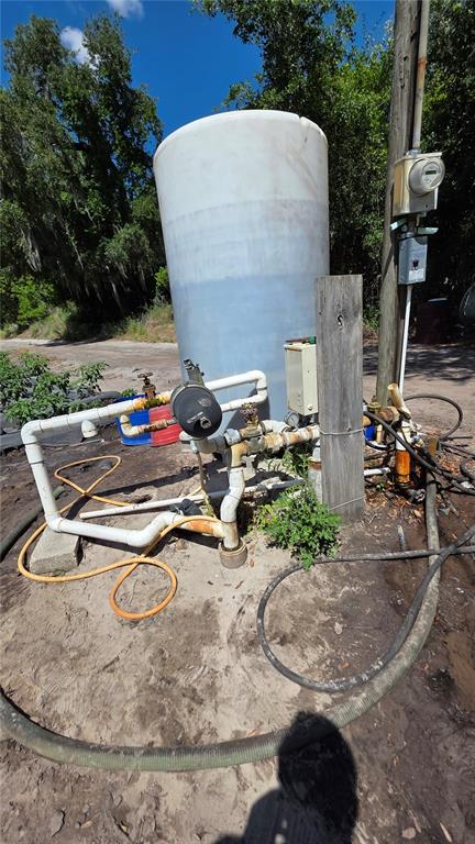 An outdoor water storage tank and pump system are situated on a dirt lot — GALLAGHER ROAD, DOVER, FL