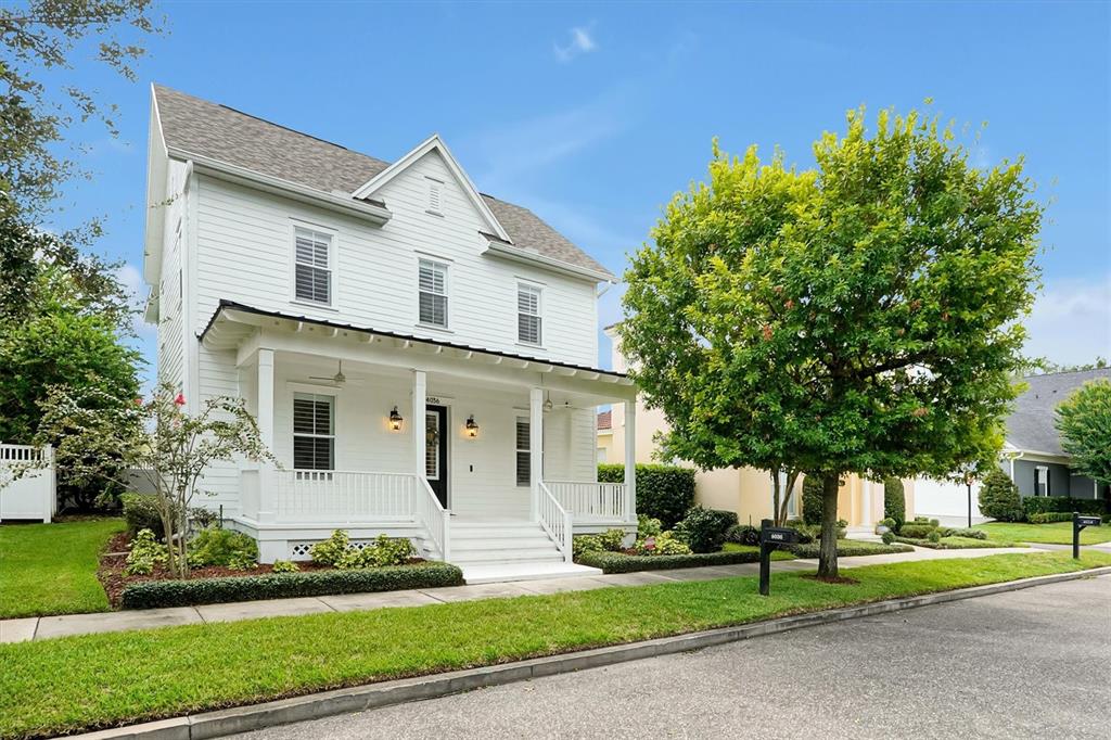 A two-story white house with a front porch and a large tree in the yard — 4036 HAWS LANE, ORLANDO, FL