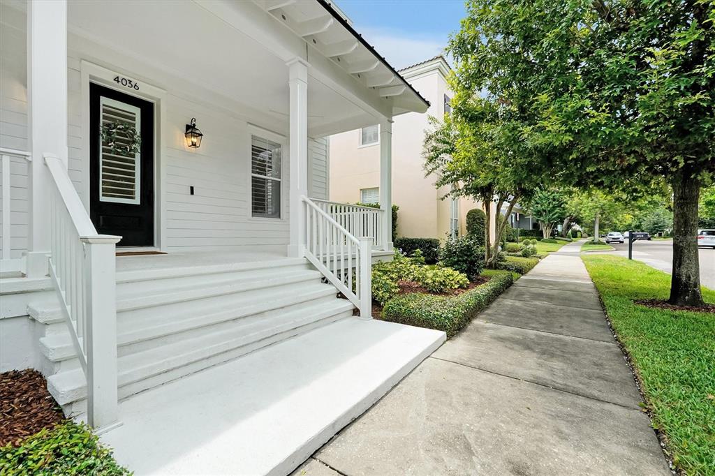 A white house exterior features a front porch with stairs and a black front door — 4036 HAWS LANE, ORLANDO, FL