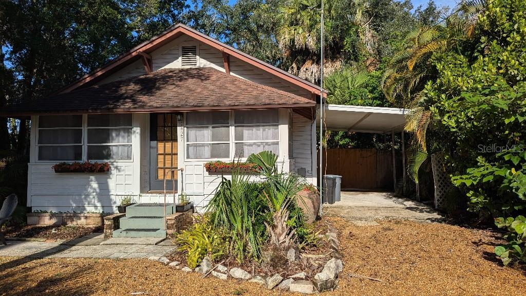 A single-story house with white siding, a brown roof, and an attached carport — 7427 CHAPEL AVENUE, NEW PORT RICHEY, FL