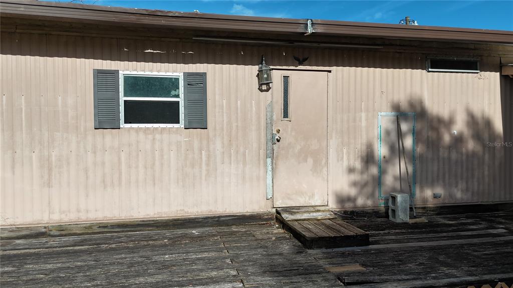 The exterior of a mobile home features a wooden deck, a door, and a window — 3216 JACK JONES ROAD, WAUCHULA, FL