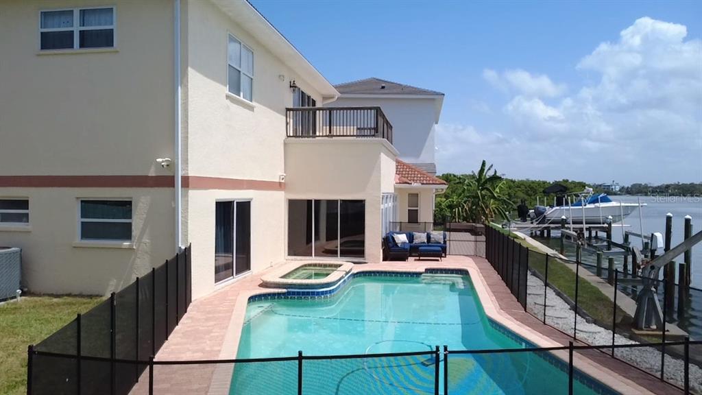 A two-story house features a backyard swimming pool, a hot tub, and a private boat dock — 919 KEY WAY, NOKOMIS, FL
