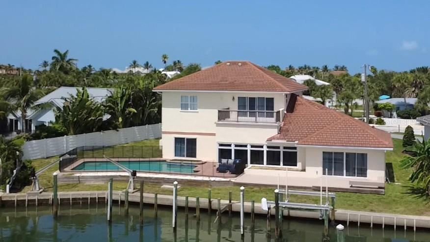 An aerial view of a two-story house with a swimming pool and a private boat dock — 919 KEY WAY, NOKOMIS, FL