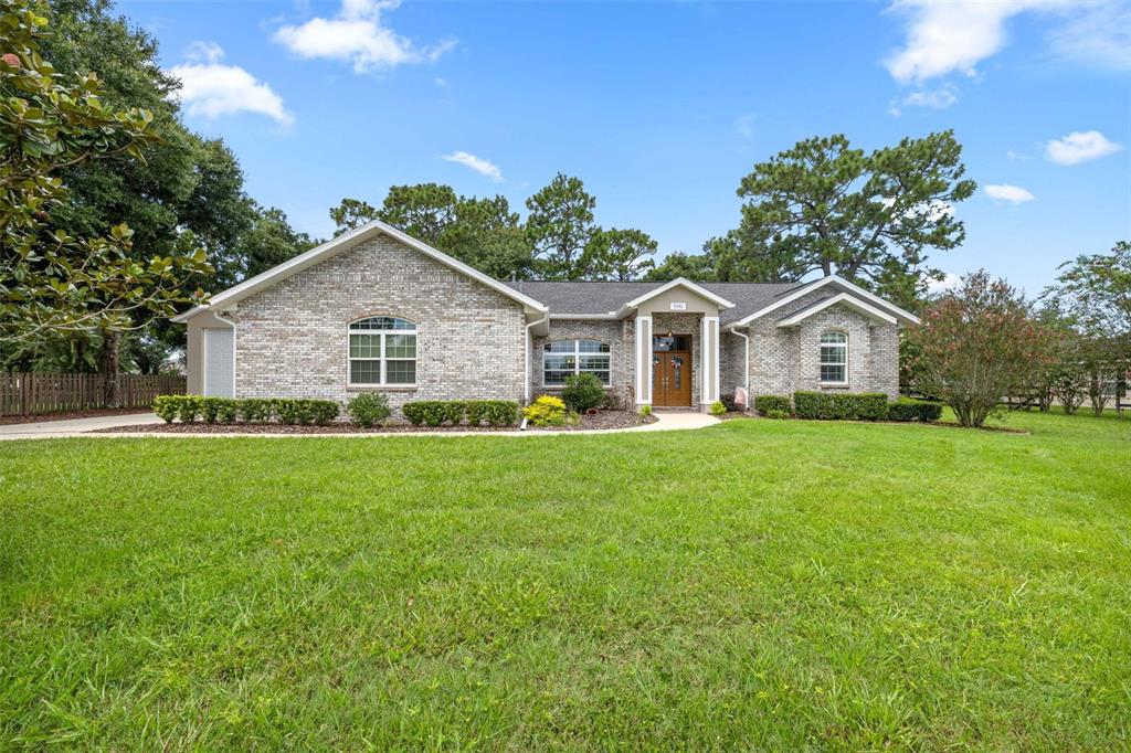 A single-story brick house with a front lawn, arched windows, and a covered entryway — 5592 NE 61ST AVENUE ROAD, SILVER SPRINGS, FL