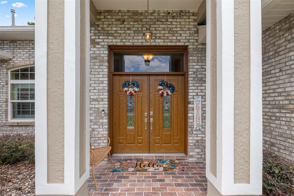 A front entryway features double wooden doors with decorative wreaths and a brick porch — 5592 NE 61ST AVENUE ROAD, SILVER SPRINGS, FL