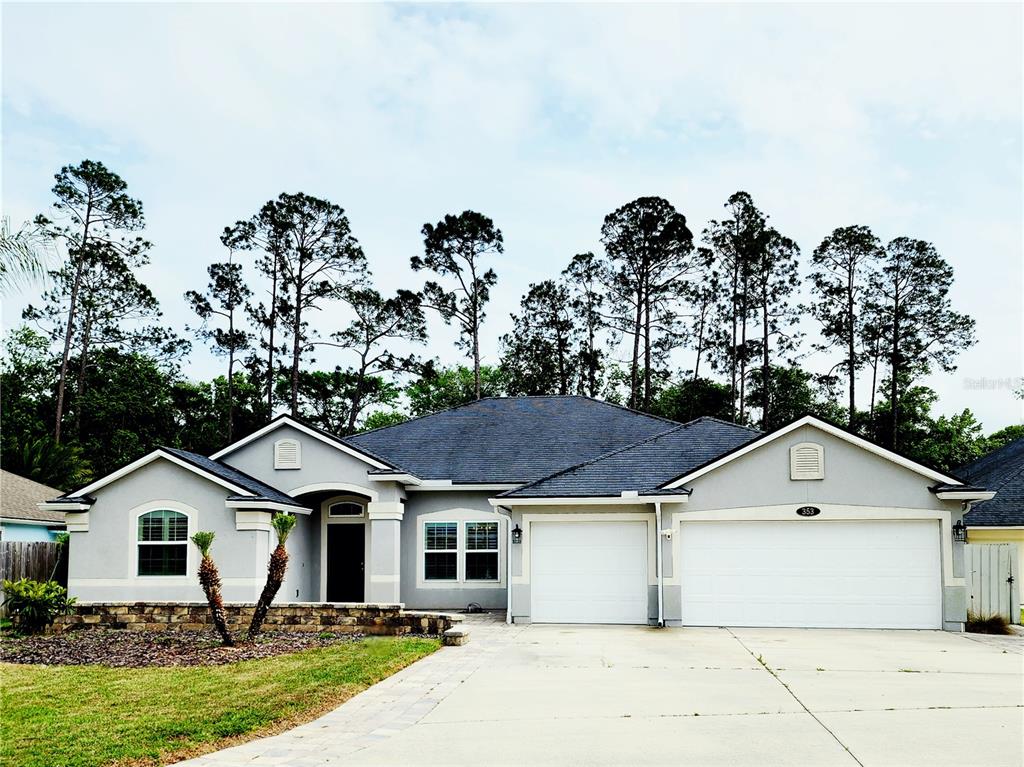 A single-story house with a gray exterior, a three-car garage, and a paved driveway — 353 CRESCENT KEY DRIVE, ST AUGUSTINE, FL