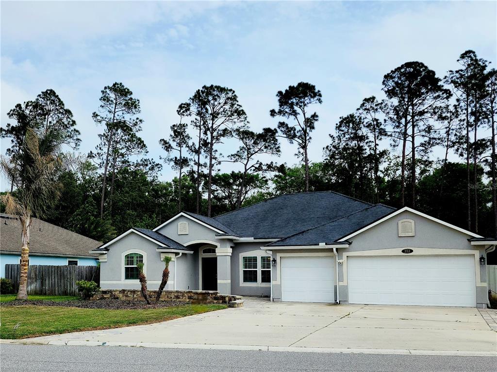 A single-story house with a gray exterior, a three-car garage, and a large driveway — 353 CRESCENT KEY DRIVE, ST AUGUSTINE, FL