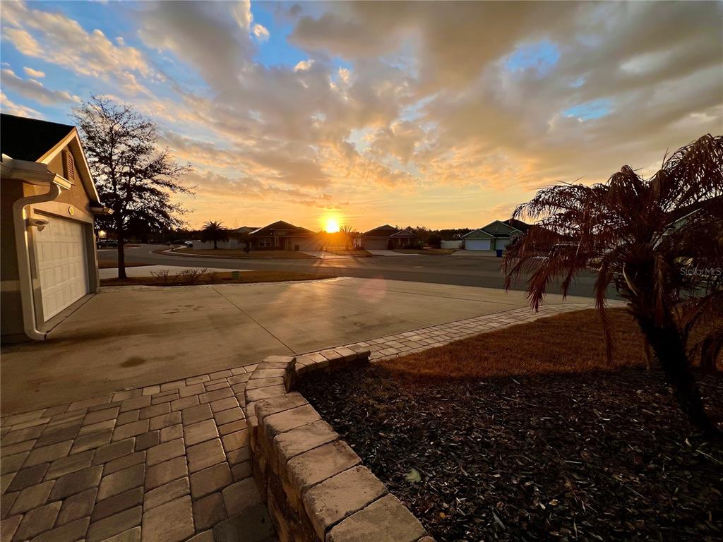 A view of a residential street at sunset from a paved driveway and patio — 353 CRESCENT KEY DRIVE, ST AUGUSTINE, FL
