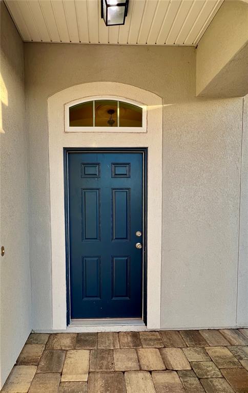A dark blue front door with a transom window sits under a covered entryway — 353 CRESCENT KEY DRIVE, ST AUGUSTINE, FL