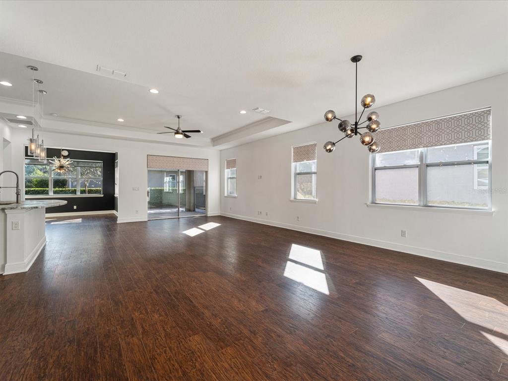 A spacious living area features dark wood floors, white walls, and a modern chandelier — 805 MOLLY, SARASOTA, FL