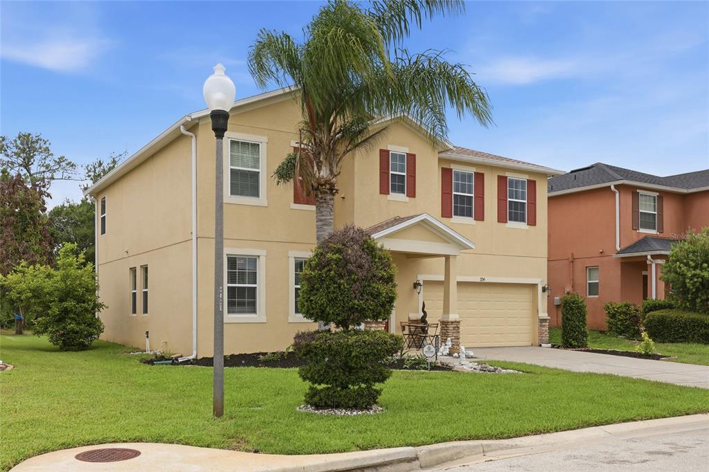 A two-story, tan stucco suburban house with red shutters and a two-car garage — 2366 SEQUOIA WAY, DAVENPORT, FL
