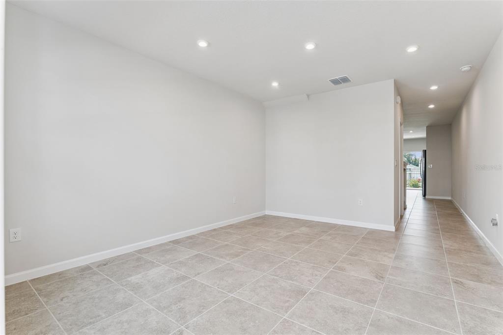 An empty room with light-colored walls, recessed lighting, and large square floor tiles — 1206 PORT BLUE WAY, LADY LAKE, FL