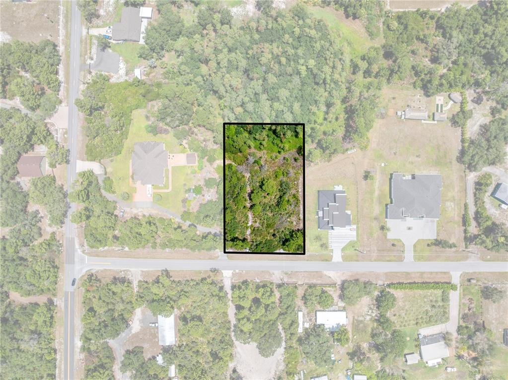 This is an aerial view of a rectangular, wooded vacant lot bordering a paved road — 0 OESTERLE ROAD, ST CLOUD, FL
