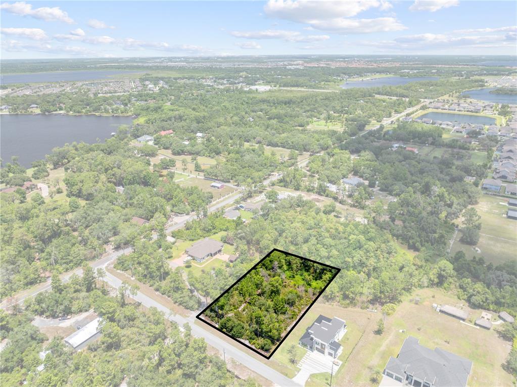 An aerial view shows a rectangular, wooded vacant lot outlined in black near a road — 0 OESTERLE ROAD, ST CLOUD, FL