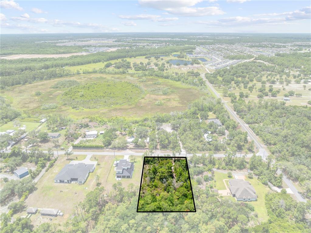 An aerial view shows a rectangular wooded lot outlined in black next to residential homes — 0 OESTERLE ROAD, ST CLOUD, FL
