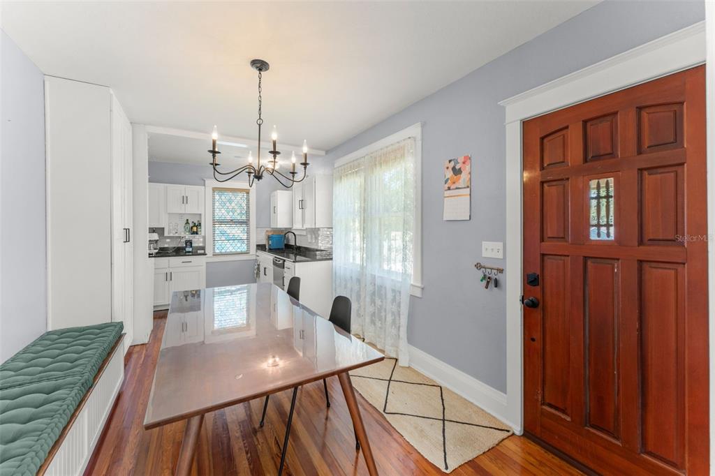 A brick path leads through a grassy backyard toward a two-story house with a screened porch — 1018 S ELM AVENUE, SANFORD, FL